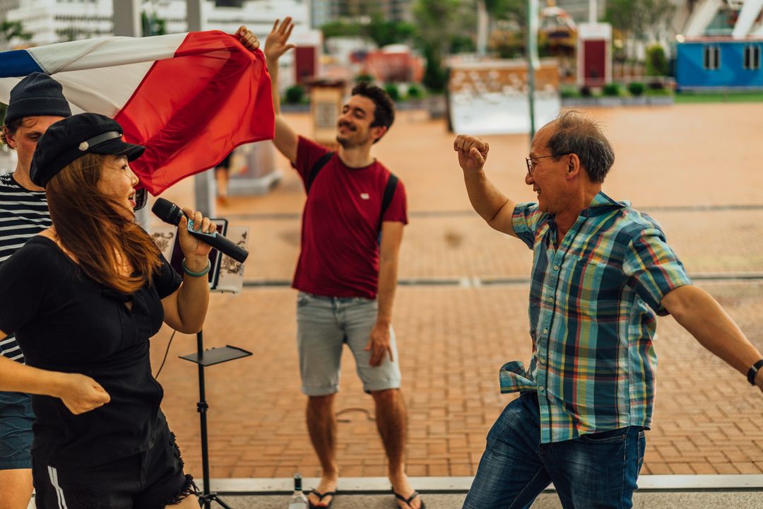 Three man dancing while a woman sings in Hong Kong city center.